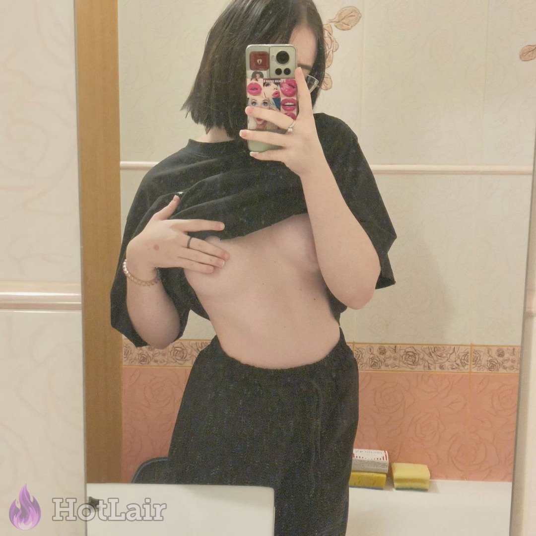 Brunette taking mirror selfie lifting shirt to flash underboob