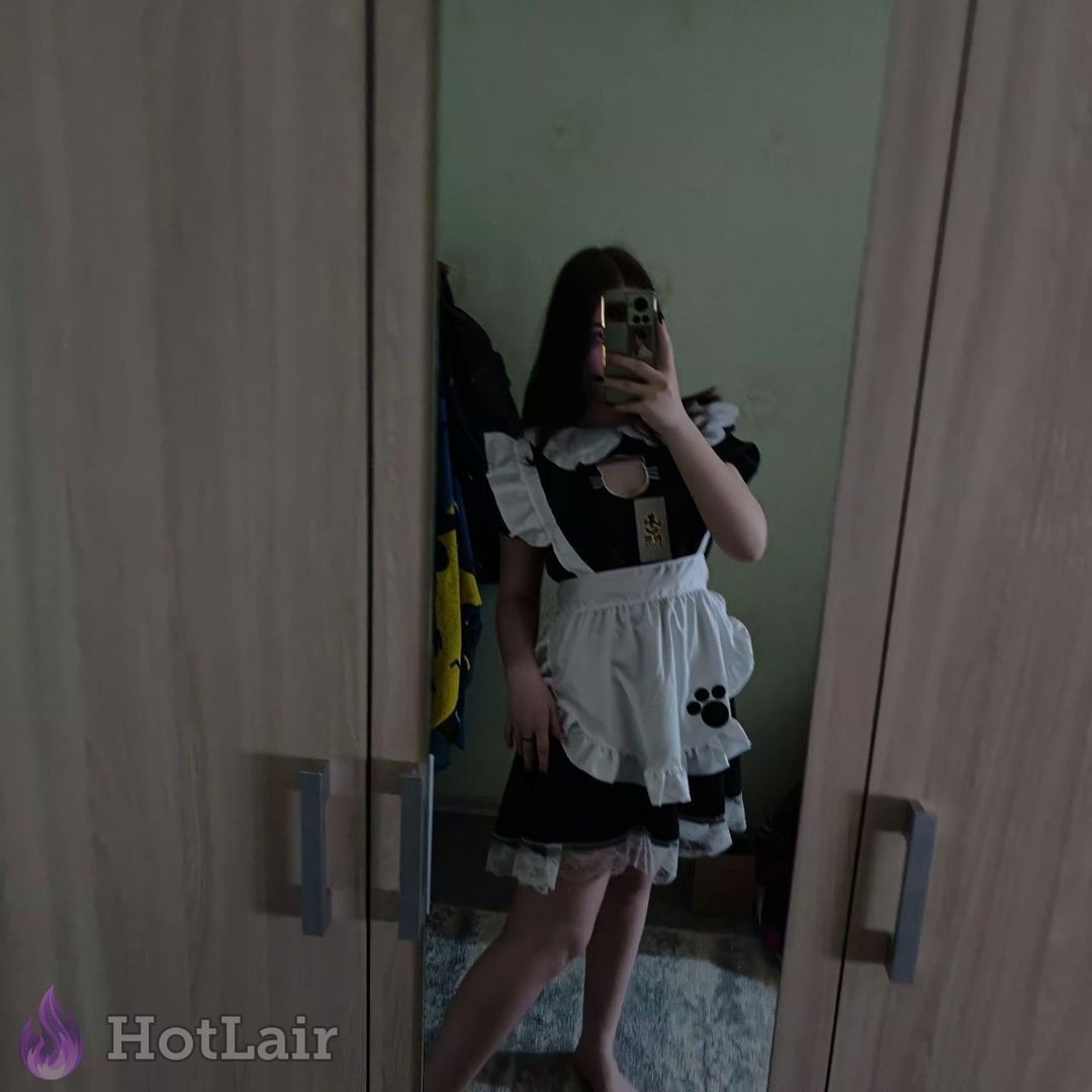 Sexy girl in black and white maid outfit taking mirror selfie