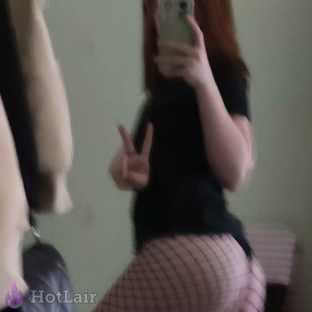Girl in fishnet stockings posing in mirror with peace sign