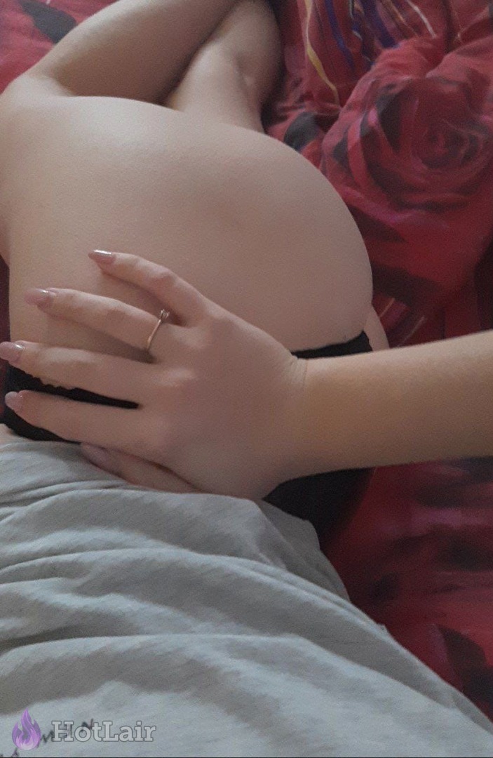 Close-up of perfect round ass with hand grabbing cheek on bed