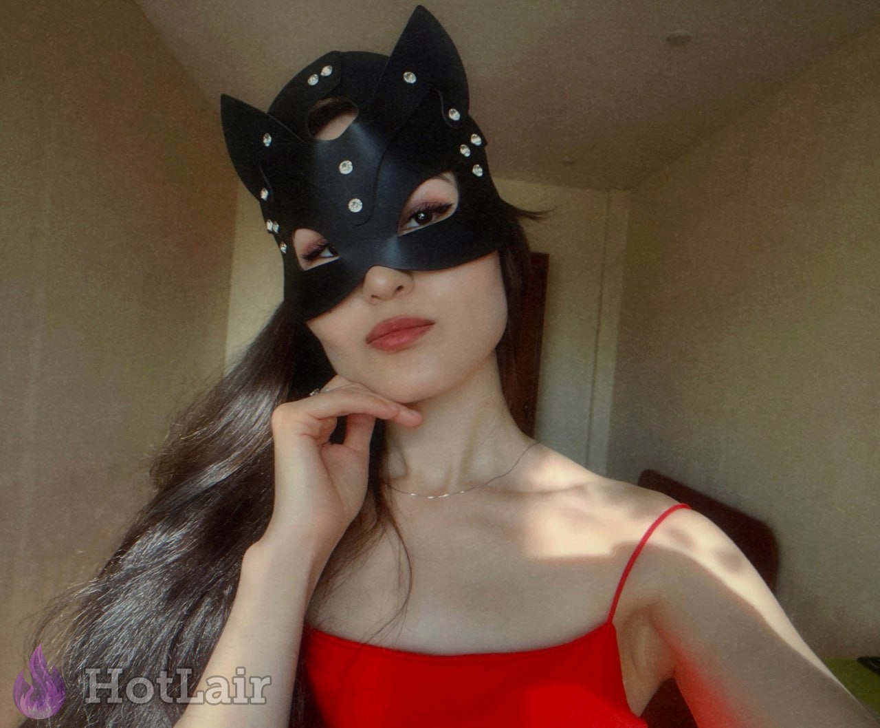 Seductive Asian beauty in black cat mask and red top posing teasingly, erotic close-up portrait