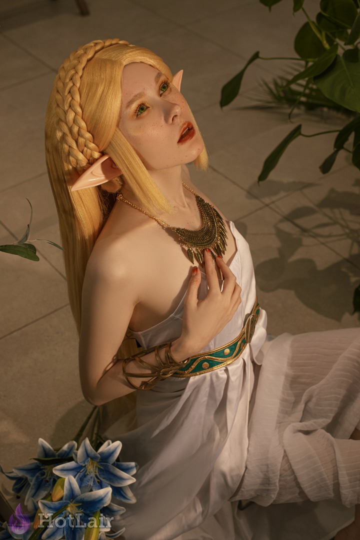 Stunning blonde elf with long braided hair and ornate gold jewelry posing elegantly while looking up with seductive expression