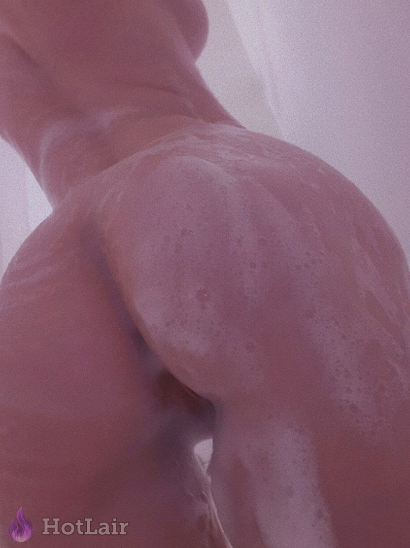 Wet soapy perfect round ass covered in bubbles in the shower, glistening skin and sensual curves under pink lighting