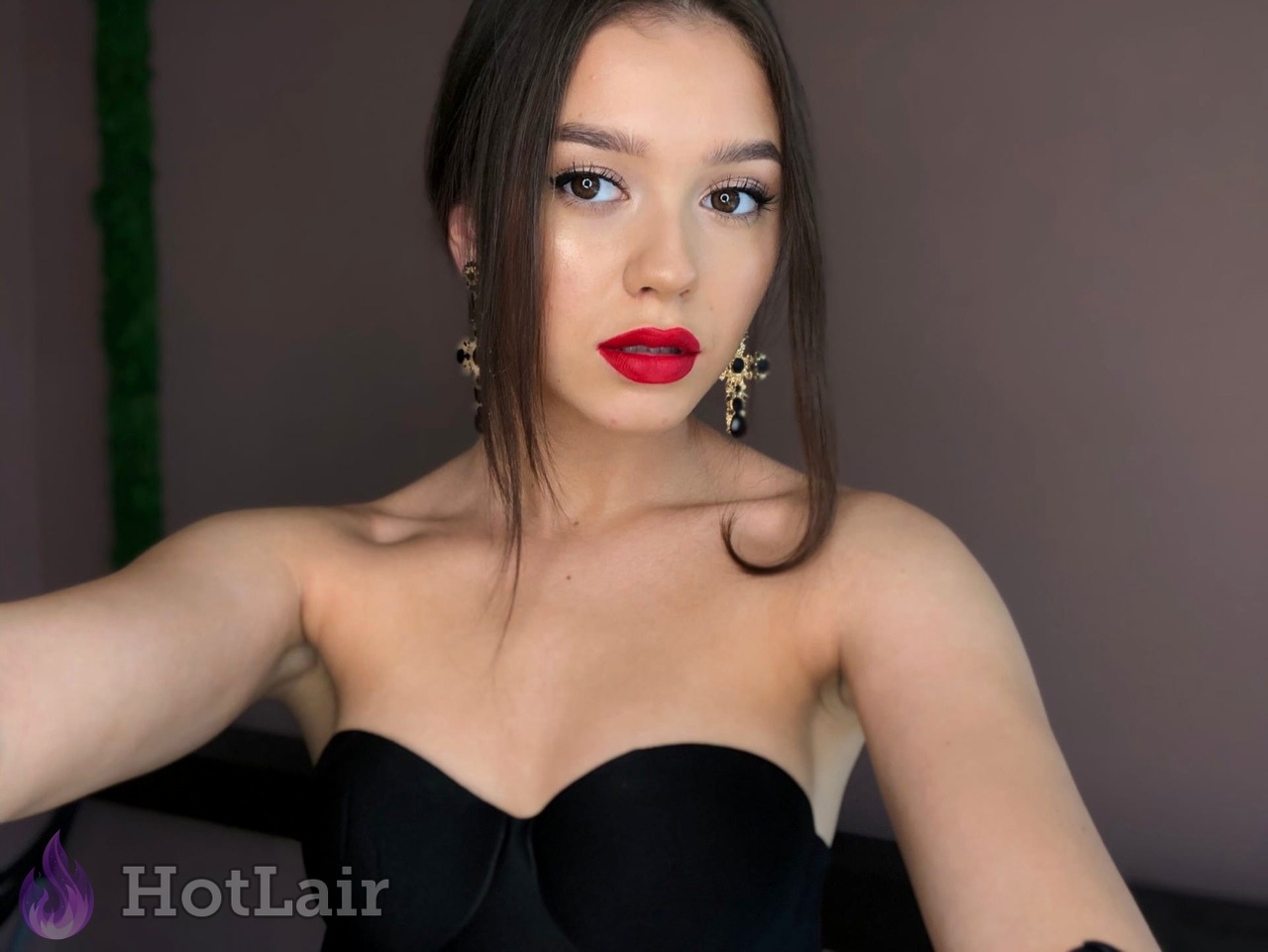 Beautiful brunette with bright red lipstick in black strapless bra portrait