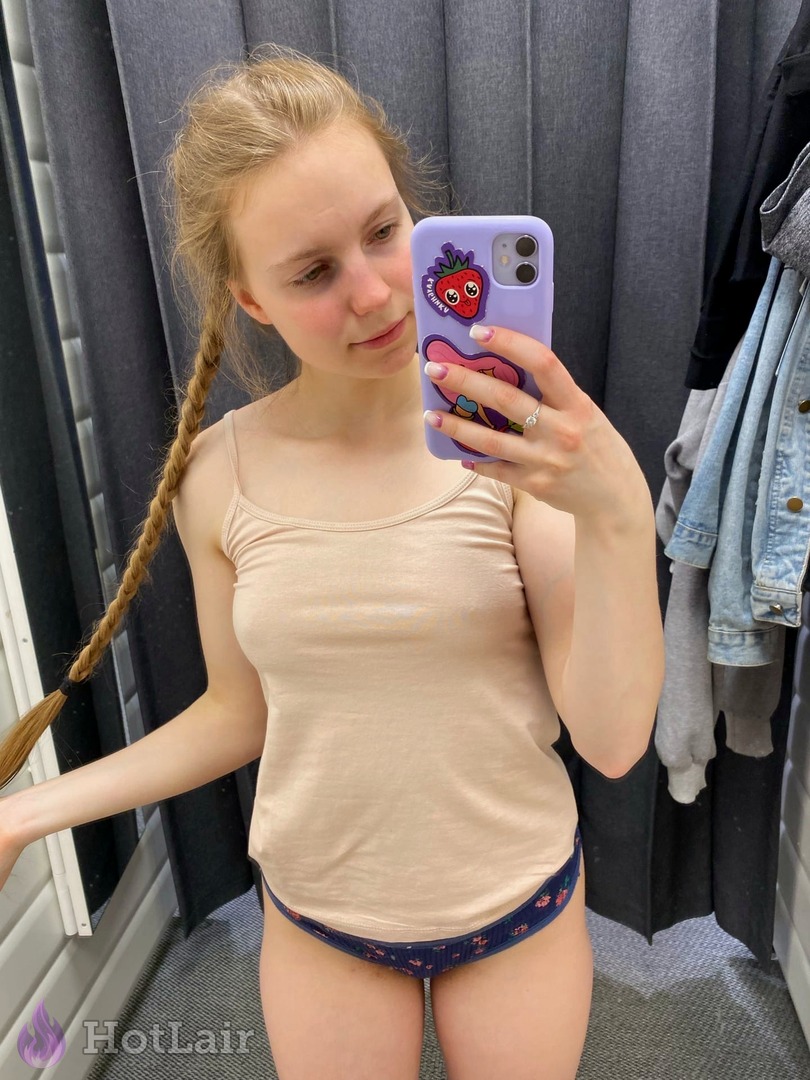 Pretty blonde teen with braid taking selfie in beige tank top and floral panties, cute facial expression