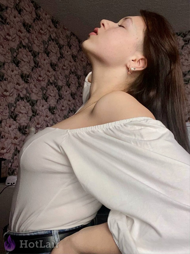 Attractive brunette in white off-shoulder top tilting her head back sensually exposing neck and shoulders