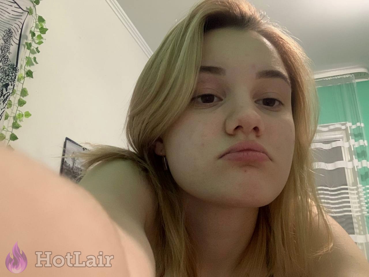 Pretty young blonde taking close-up selfie with natural face and pouty lips expression