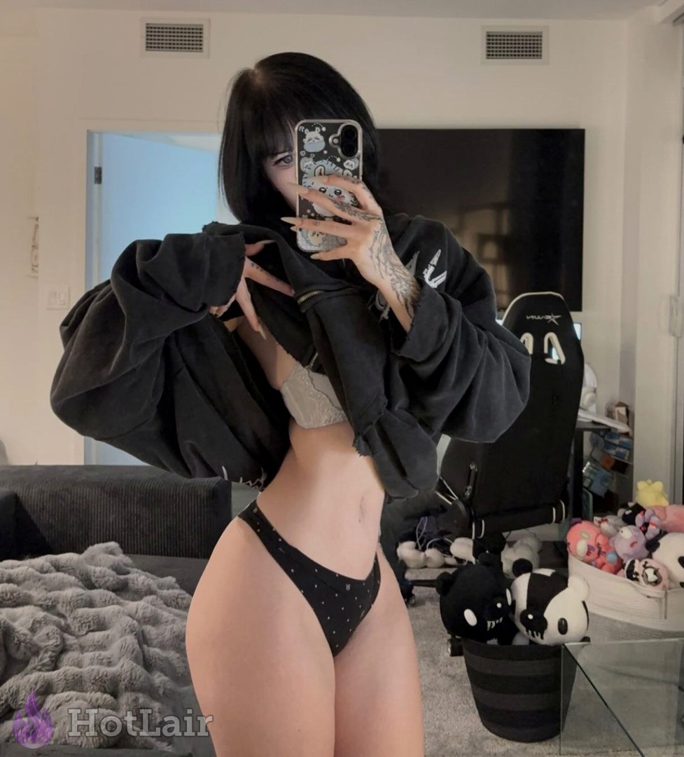 Tattooed brunette lifts oversized black hoodie revealing lace bra and tiny panties in mirror selfie