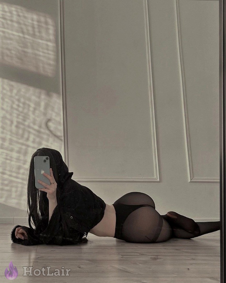Brunette in black jacket and sheer black panties lies on floor taking ass-focused mirror selfie