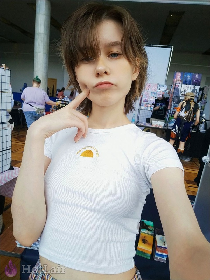 Cute short-haired brunette making funny pouty face selfie in white crop top