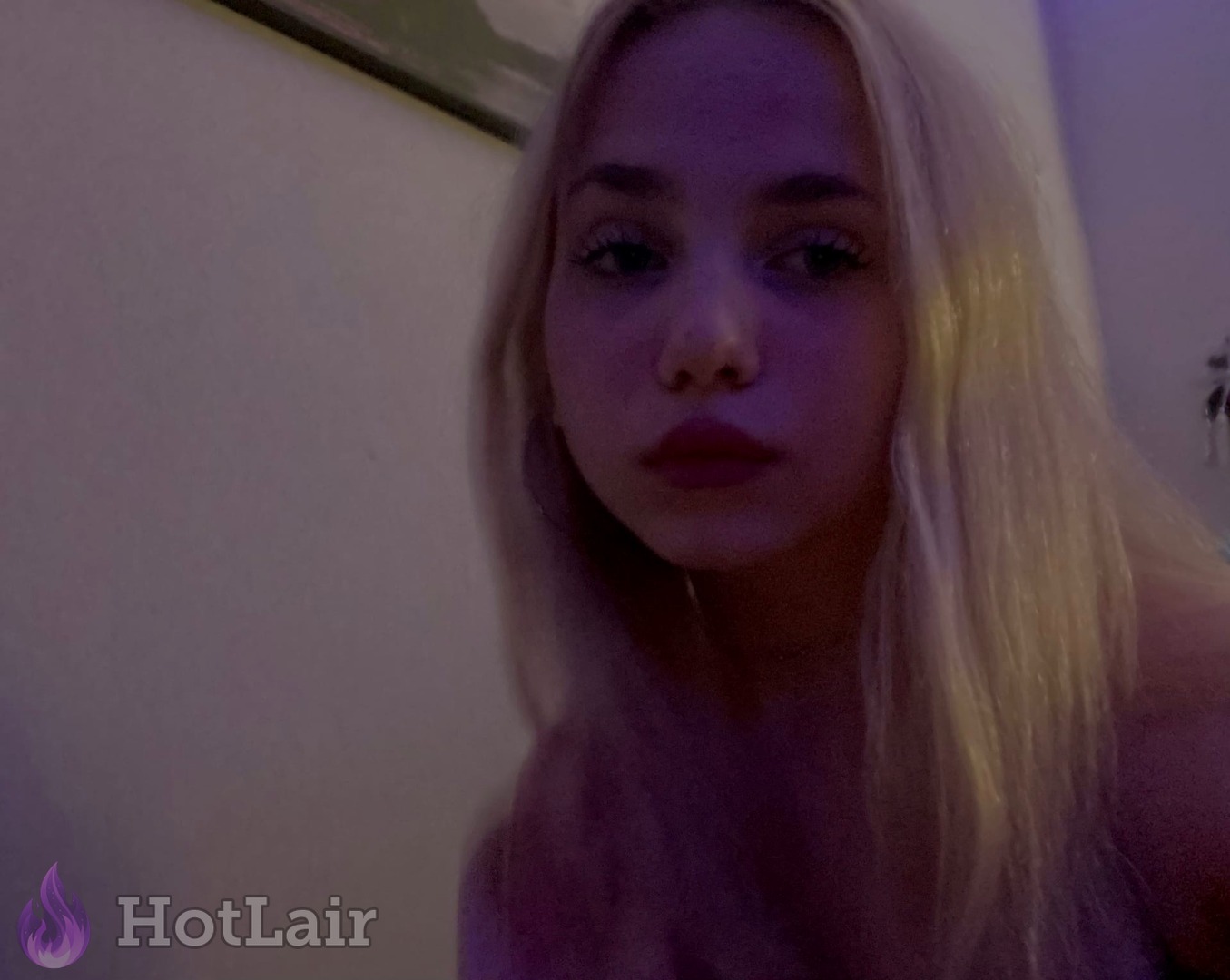 Seductive platinum blonde with long straight hair and smoky makeup staring intensely at camera in soft purple lighting, erotic close-up portrait