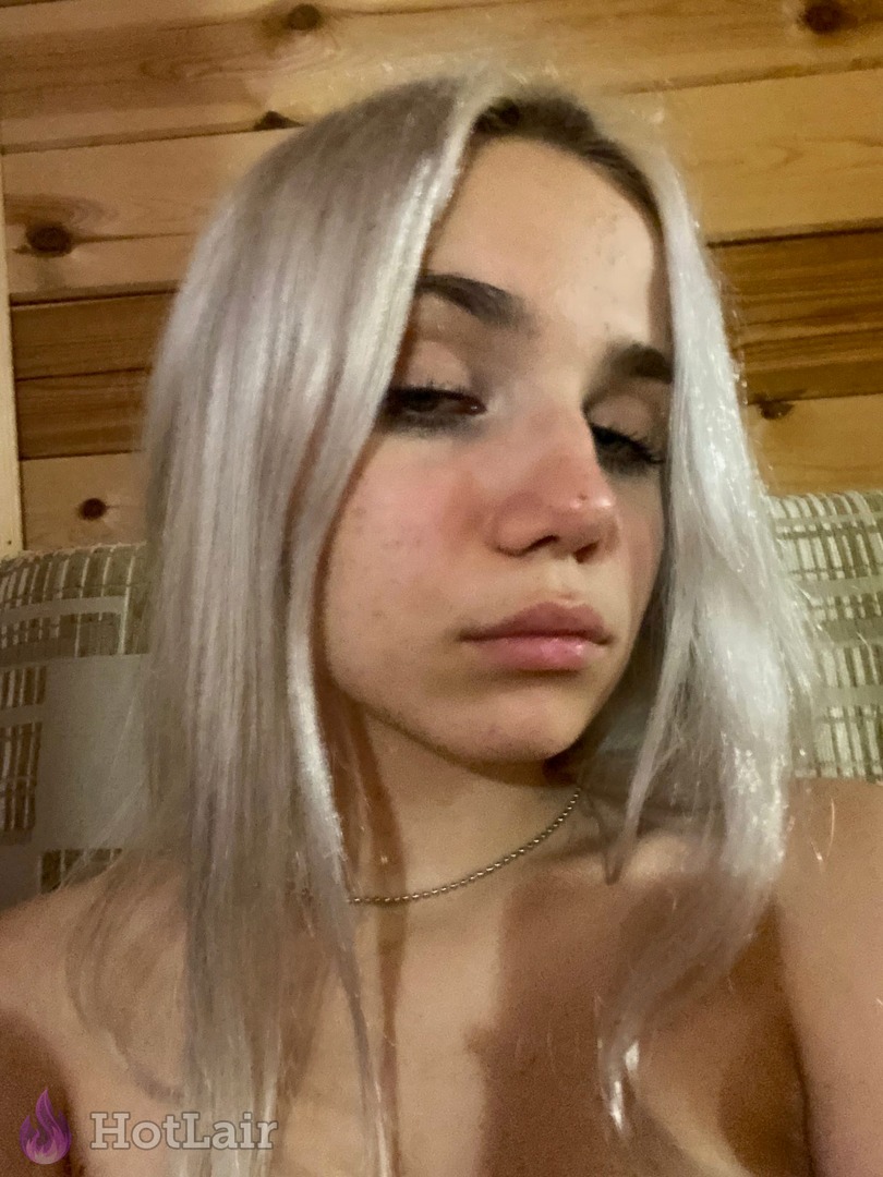 Gorgeous platinum blonde with flawless skin and long wet-look hair posing topless with closed eyes and soft expression