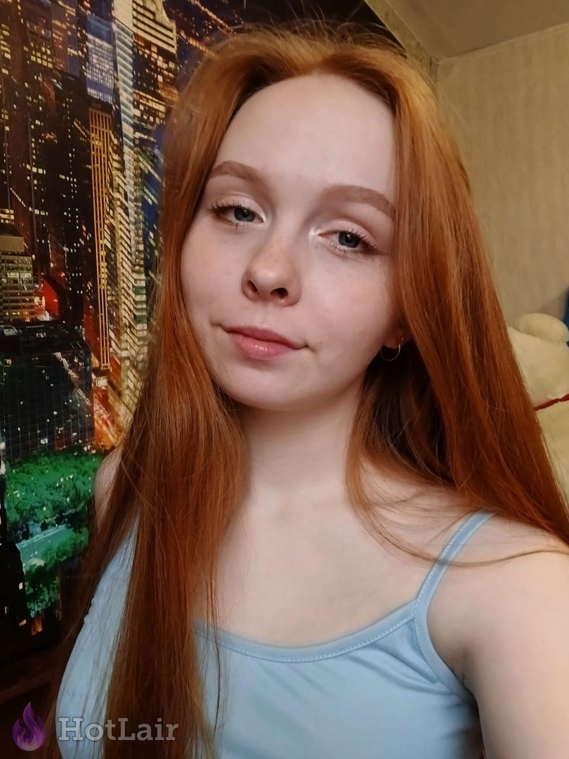 Beautiful young redhead with long ginger hair and pretty eyes portrait