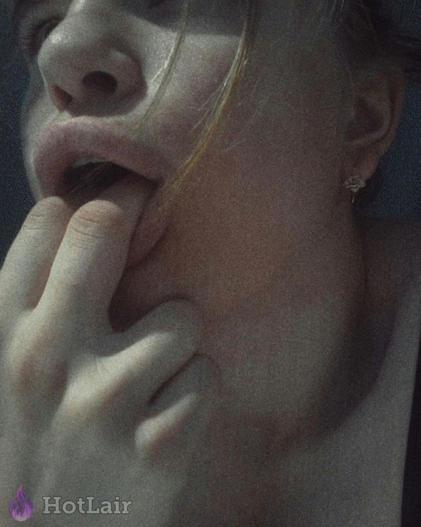 Close-up of a girl sensually sucking her finger with seductive expression